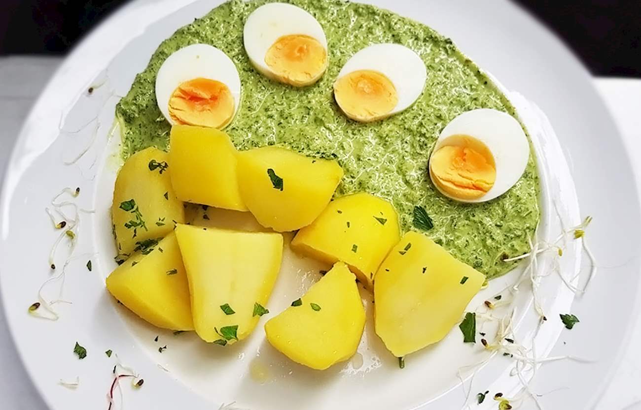 Plate of Grüne Soße, a green sauce made from herbs, served with boiled potatoes and sliced hard-boiled eggs.
